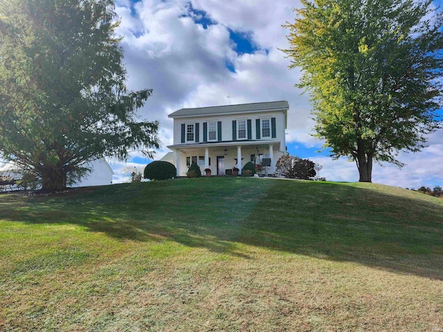 colonial-style house featuring a front yard and a porch