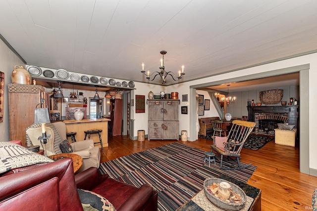 living room with a notable chandelier, wood-type flooring, and a fireplace