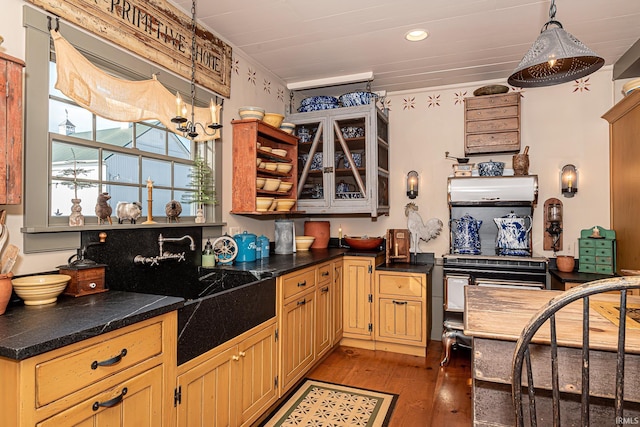 kitchen with light brown cabinetry, dark hardwood / wood-style flooring, pendant lighting, and ornamental molding