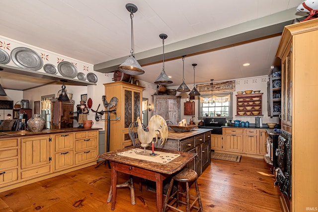 kitchen featuring sink, hanging light fixtures, and wood-type flooring