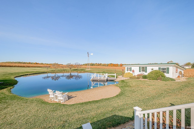 view of dock with a water view and a lawn