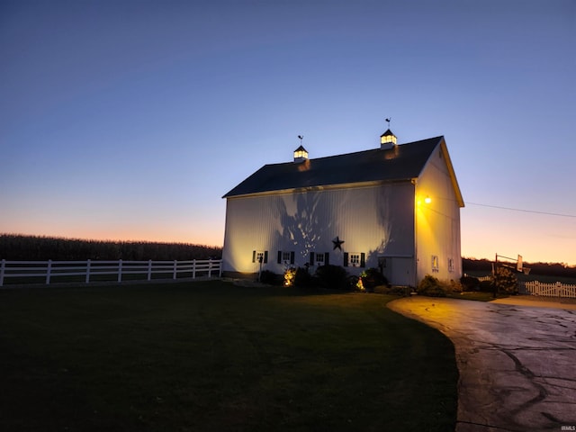 property exterior at dusk featuring a lawn