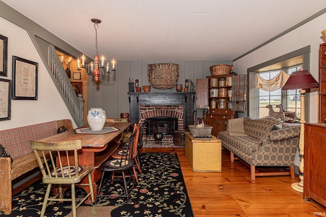 dining area with ornamental molding, a chandelier, a fireplace, and hardwood / wood-style floors