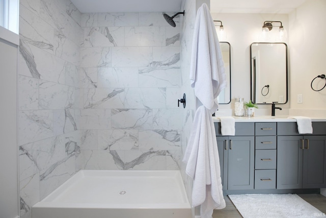 bathroom with a tile shower, hardwood / wood-style flooring, and vanity