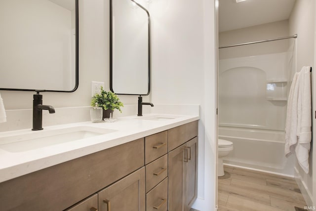 full bathroom featuring vanity, shower / washtub combination, hardwood / wood-style flooring, and toilet