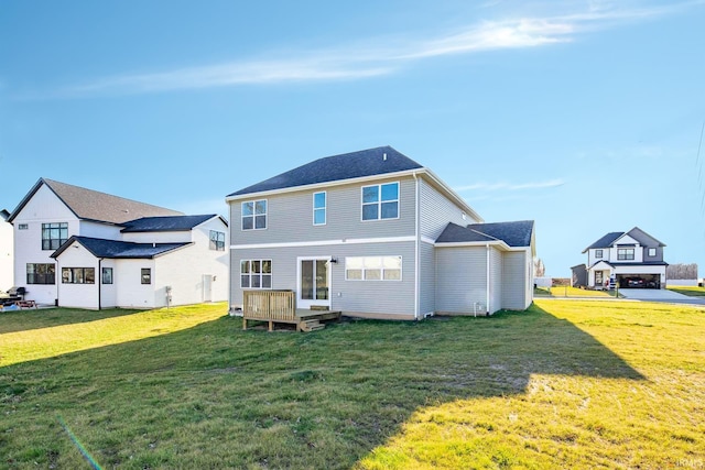 rear view of property with a wooden deck and a lawn