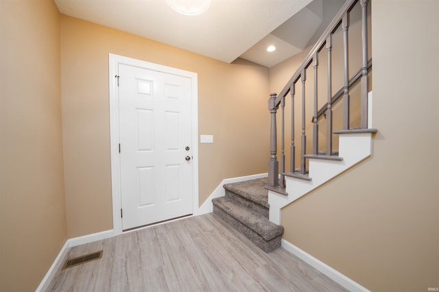 entrance foyer with a textured ceiling and light hardwood / wood-style flooring