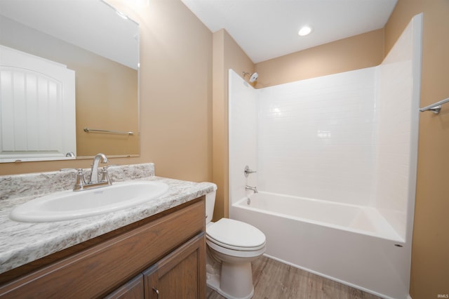 full bathroom featuring vanity, washtub / shower combination, wood-type flooring, and toilet