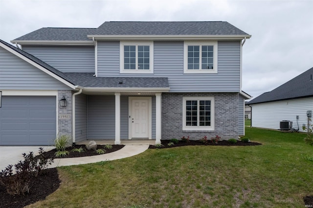 front of property featuring central air condition unit, a front lawn, and a garage