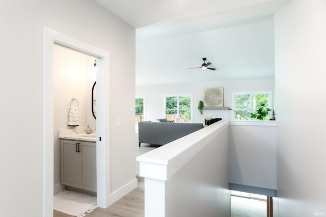 hall with light wood-type flooring and a wealth of natural light