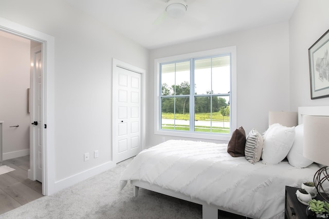 bedroom with light hardwood / wood-style flooring, a closet, and ceiling fan