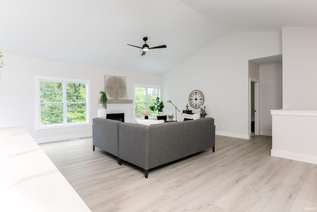 living room featuring light hardwood / wood-style floors, high vaulted ceiling, plenty of natural light, and ceiling fan