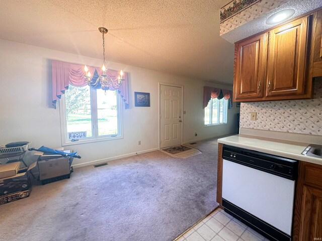 kitchen featuring white dishwasher, hanging light fixtures, a textured ceiling, and an inviting chandelier