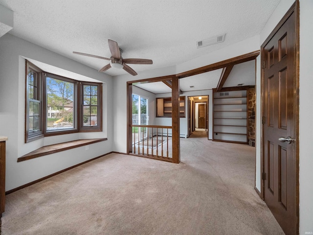 spare room with light carpet, a textured ceiling, and ceiling fan