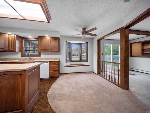 kitchen featuring dark carpet, white dishwasher, sink, a textured ceiling, and ceiling fan