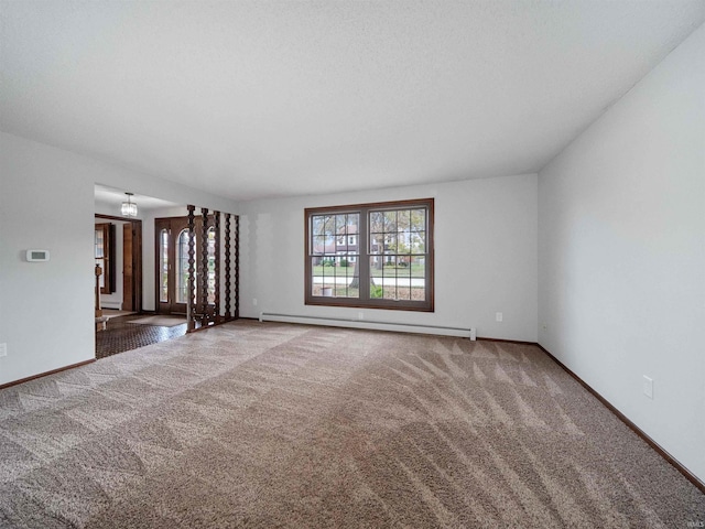 spare room featuring carpet and a baseboard heating unit