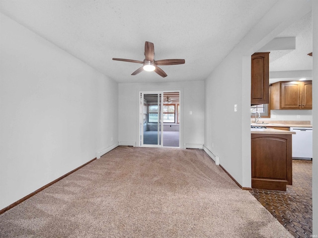 unfurnished living room featuring ceiling fan, a textured ceiling, dark carpet, baseboard heating, and sink