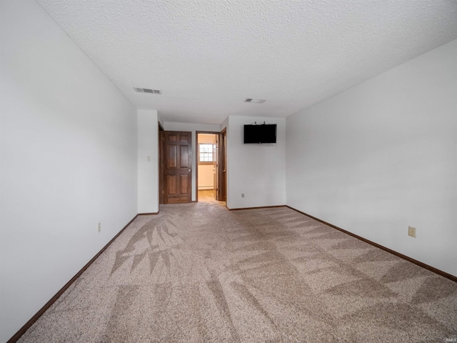 carpeted spare room with a textured ceiling