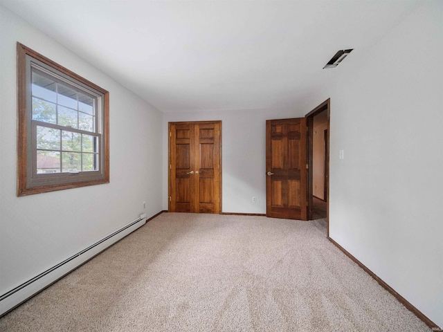 unfurnished bedroom with carpet and a baseboard radiator