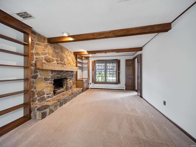 unfurnished living room featuring beamed ceiling, a textured ceiling, a fireplace, and carpet floors