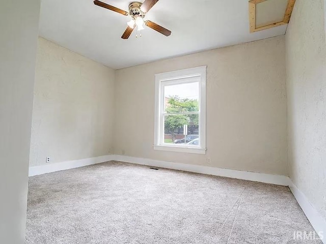 carpeted spare room with ceiling fan