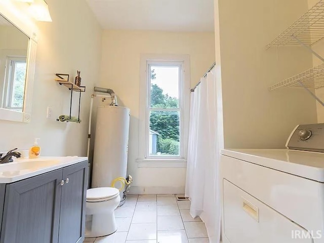 bathroom featuring washer / dryer, water heater, toilet, tile patterned floors, and vanity