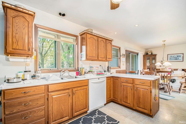 kitchen featuring dishwasher, hanging light fixtures, kitchen peninsula, sink, and ceiling fan