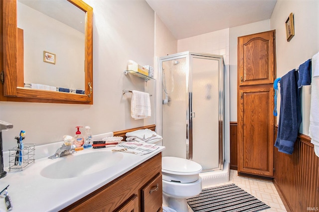 bathroom with a shower with door, vanity, and toilet