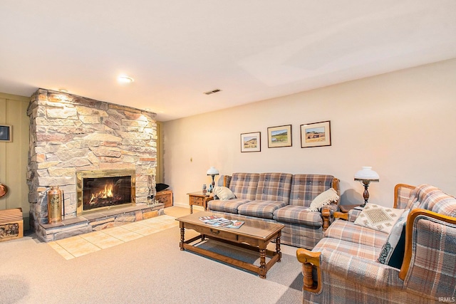 carpeted living room featuring a stone fireplace