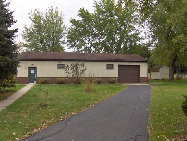 view of front of property with a shed, a front lawn, and a garage