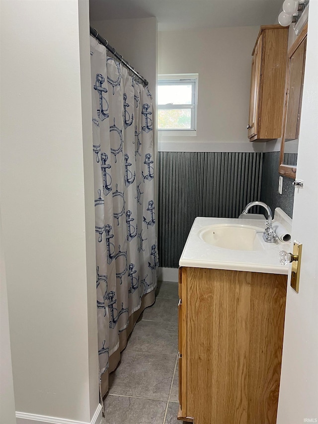 bathroom featuring walk in shower, vanity, and tile patterned flooring