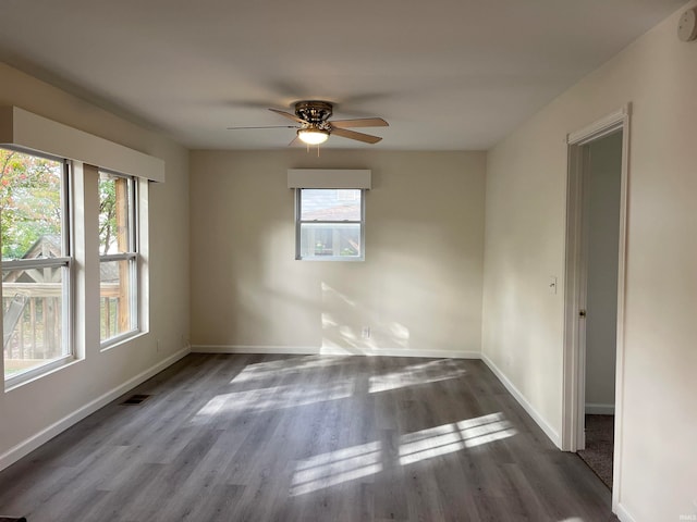 unfurnished room with dark wood-type flooring, ceiling fan, and plenty of natural light