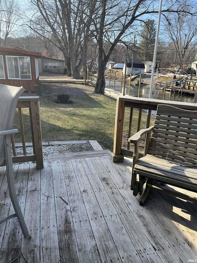 deck featuring a water view and a lawn