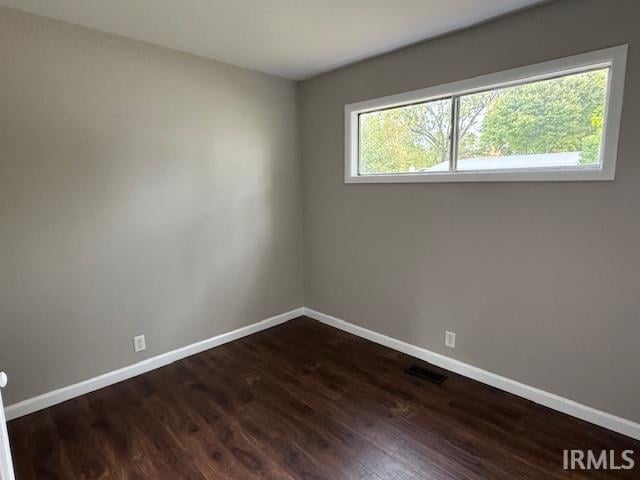 unfurnished room featuring dark hardwood / wood-style flooring