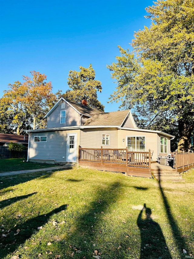 back of house featuring a deck and a lawn