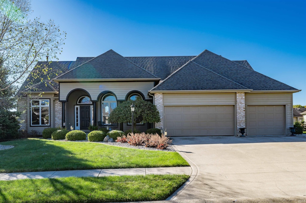 view of front of home with a front yard and a garage