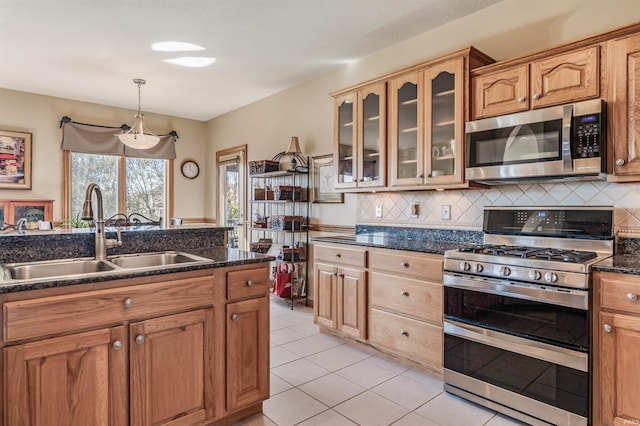 kitchen with tasteful backsplash, light tile patterned floors, sink, pendant lighting, and stainless steel appliances