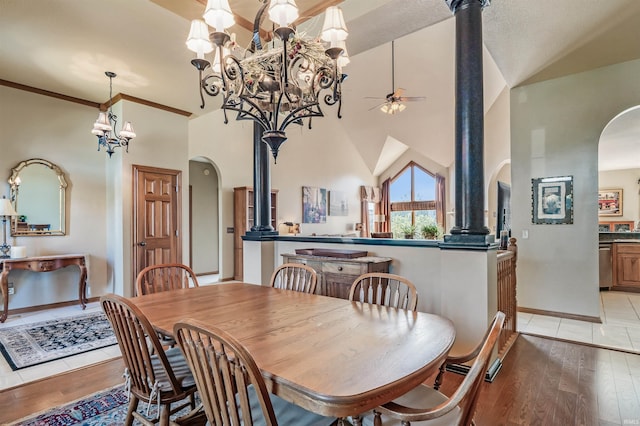 dining area with light hardwood / wood-style floors, high vaulted ceiling, and ceiling fan with notable chandelier