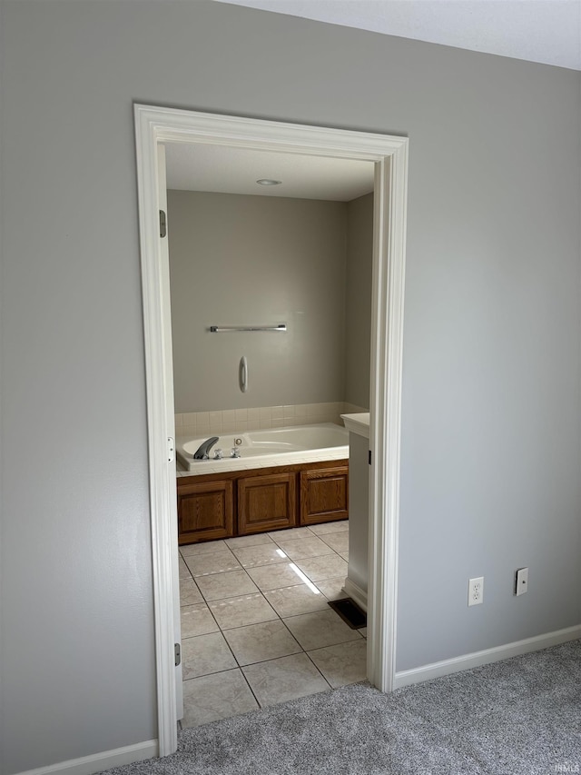 bathroom with tile patterned floors and a tub to relax in