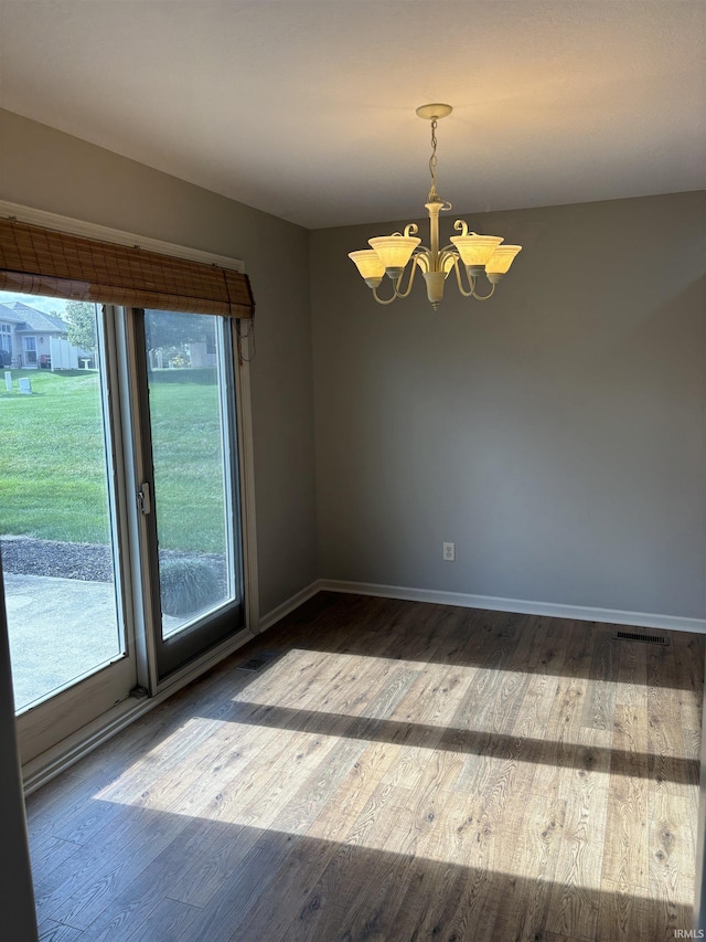 unfurnished room featuring a notable chandelier and wood-type flooring