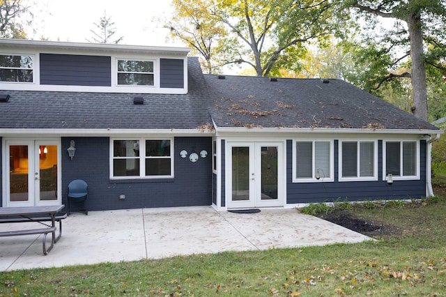 rear view of property with brick siding, french doors, a shingled roof, and a patio area