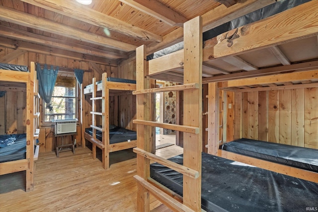 bedroom with wooden ceiling, beam ceiling, wood-type flooring, and wooden walls