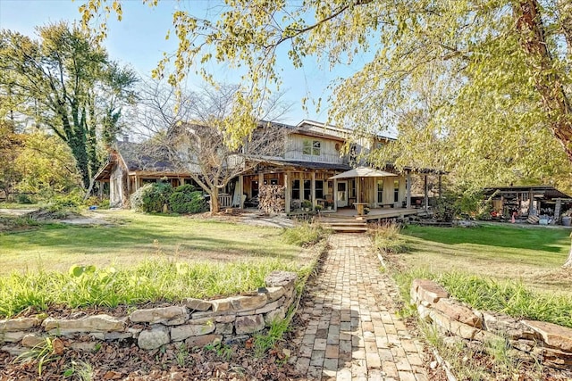 rear view of house featuring a yard and a porch