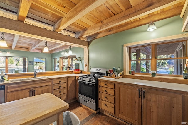 kitchen featuring dark wood-type flooring, beam ceiling, stainless steel gas stove, and hanging light fixtures