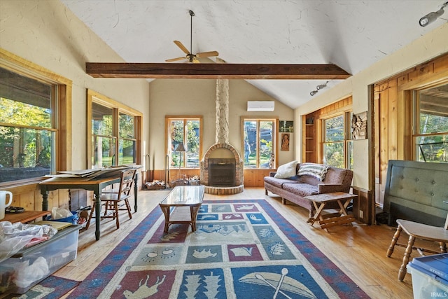 sunroom featuring ceiling fan, an AC wall unit, and vaulted ceiling with beams