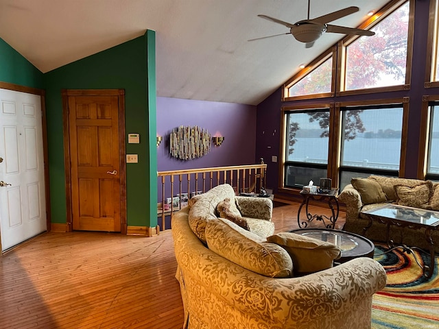 living room with light hardwood / wood-style flooring, lofted ceiling, and ceiling fan