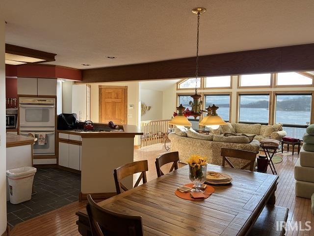 720 Ln 800 Snow Lk, Fremont, IN 46737 - dining space featuring dark wood-style flooring and a chandelier