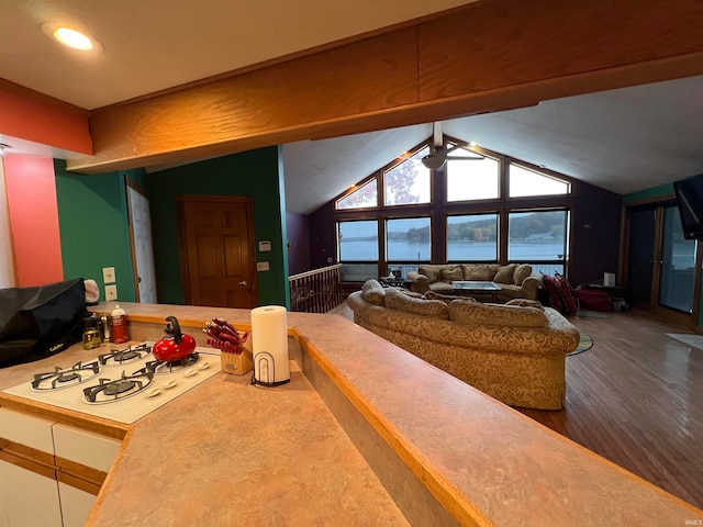 living room with ceiling fan, vaulted ceiling, and hardwood / wood-style floors