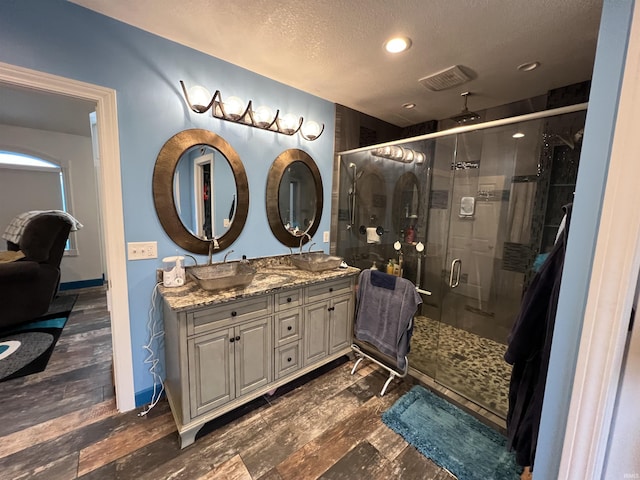 720 Ln 800 Snow Lk, Fremont, IN 46737 - full bathroom with a textured ceiling, a shower stall, wood finished floors, double vanity, and recessed lighting