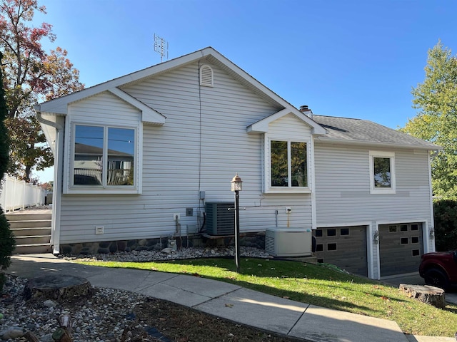 view of home's exterior with central AC unit and a garage